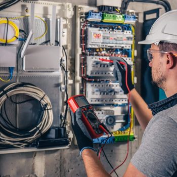 man-electrical-technician-working-switchboard-with-fuses-min (1)